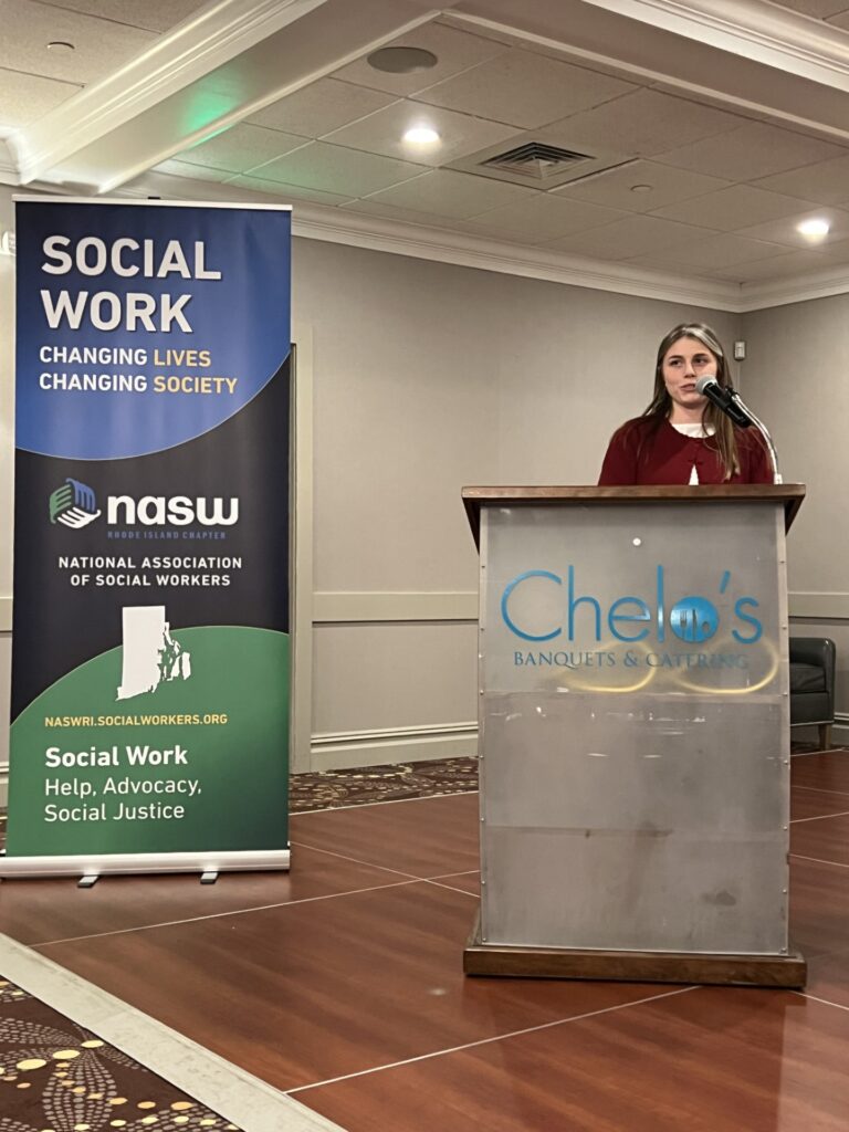 The 2025 NASW-RI Promising Practitioner for Providence College, Catherine Hein, addresses audience.